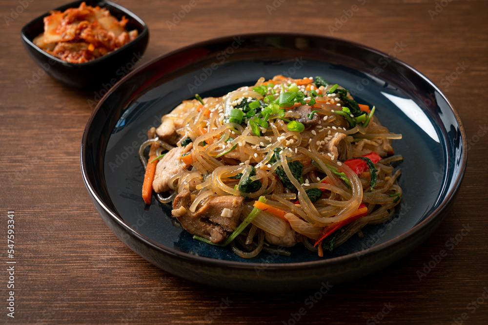 japchae or stir-fried Korean vermicelli noodles with vegetables and pork topped with white sesame