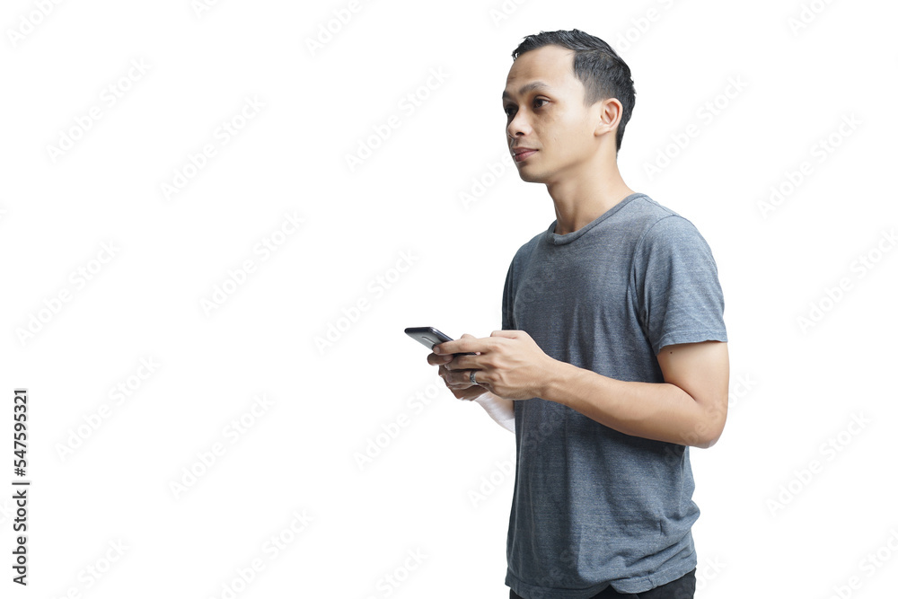 Young smiling handsome Asian man in casual attire using mobile phone isolated studio background Young smiling handsome Asian man in casual attire using mobile phone isolated studio background