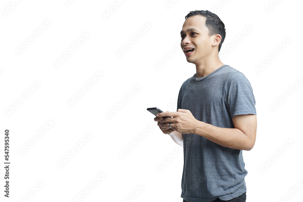 Young smiling handsome Asian man in casual attire using mobile phone isolated studio background Young smiling handsome Asian man in casual attire using mobile phone isolated studio background