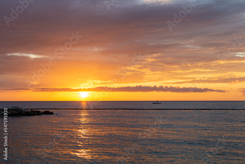 soleil levant dans un ciel orangé au dessus de la ligne d'horizon au dessus de l'océan