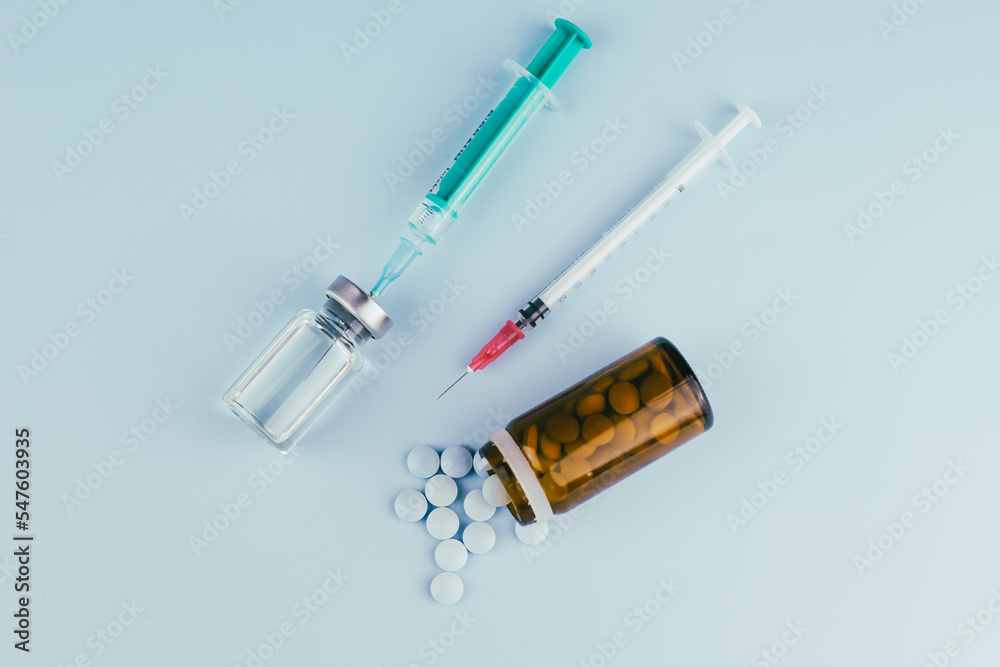 syringe with needle, vial and pills. illegal doping in sport concept, flu vaccine, aesthetic medicine or drugs, narcotics. medical items background  - obrazy, fototapety, plakaty 