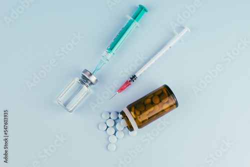 syringe with needle, vial and pills. illegal doping in sport concept, flu vaccine, aesthetic medicine or drugs, narcotics. medical items background  photo