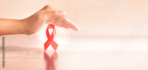 Hand covered 3d red ribbon on world map background, campaign for World AIDS Day Fototapet
