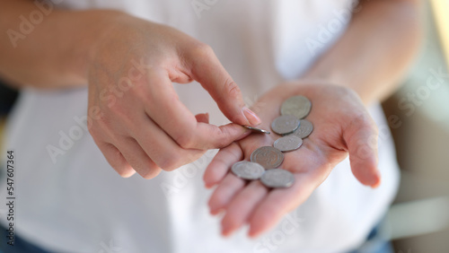 Fotografia Closeup of woman counts coins in her hands.
