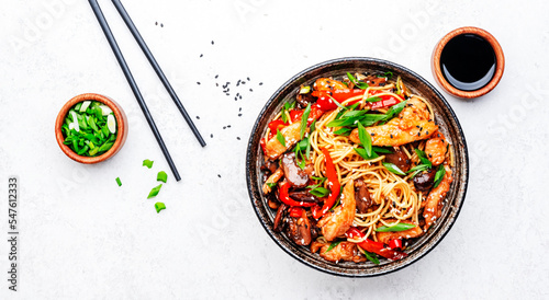 Bild auf Leinwand Stir fry egg noodles with chicken, sweet paprika, mushrooms, chives and sesame seeds in bowl