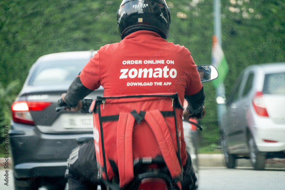 bike rider delivery boy with hot box branded with zomato the food tech ...