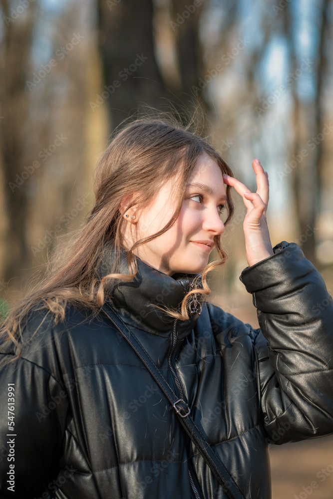 Portrait of a young beautiful woman in a dark autumn jacket. Portrait of a young beautiful woman in a dark autumn jacket.
