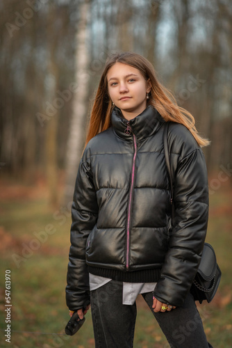 Portrait of a young beautiful woman in a dark autumn jacket.