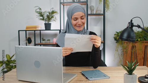 Happy muslim woman open read envelope letter. Career growth advance promotion, bank loan approve, successful admission to university monetary award long-awaited invitation great news, lottery game win
