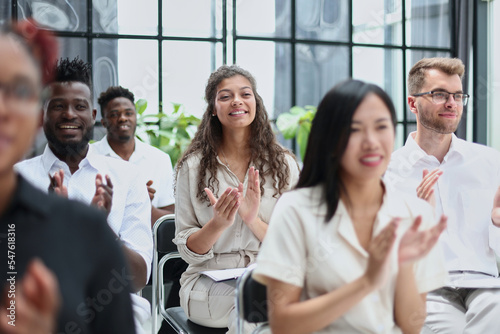 businesswoman applauding during seminar near interracial colleagues