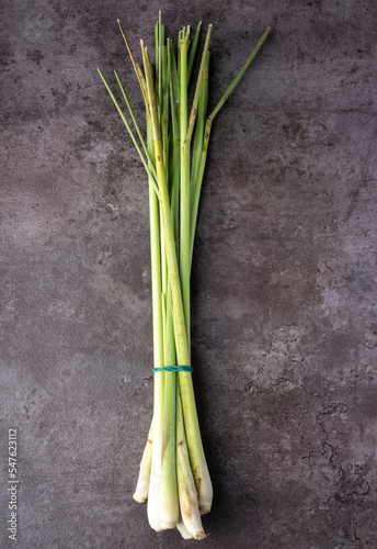 Fresh Lemongrass on dark background. Aromatic herb. Tradicional medicine. For inscent repellent herb. Top view.