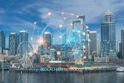 Seattle skyline with waterfront view. Skyscrapers of financial downtown at day time, Washington, USA. Decentralized economy. Blockchain, cryptography and cryptocurrency concept, hologram