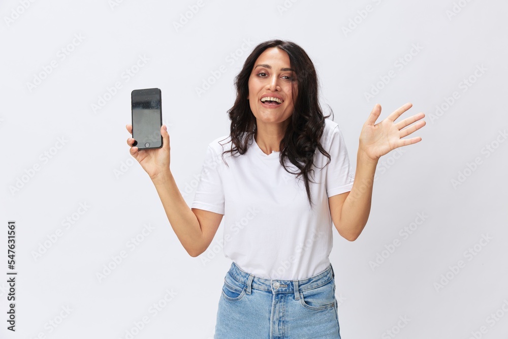 Woman blogger with a phone in her hands photo content, video call, selfie smile with teeth in a white t-shirt on a white background, copy space, emotions and gestures signals Woman blogger with a phone in her hands photo content, video call, selfie smile with teeth in a white t-shirt on a white background, copy space, emotions and gestures signals
