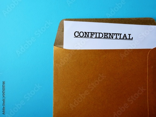 Office envelope with document typed CONFIDENTIAL, concept of data or information intended to be kept secret, secret or private, business or military top secret document photo