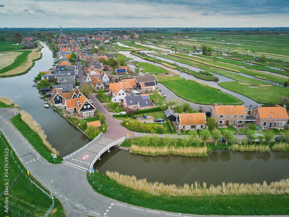 Aerial scenic view of typical Dutch village surrounded with polders and fields, North Holland, Netherlands