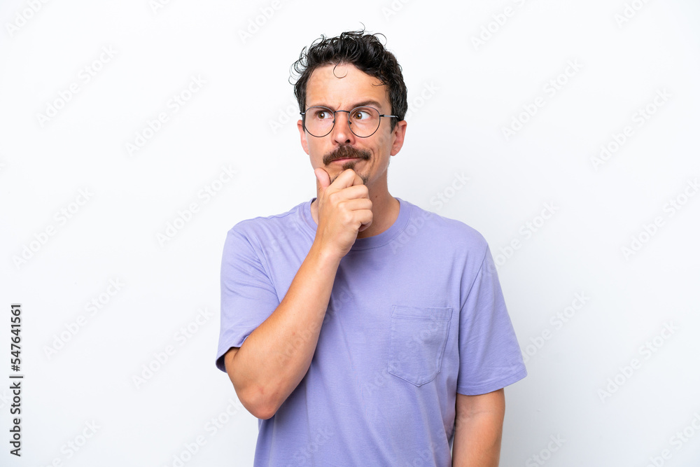 Young man with moustache isolated on white background having doubts and thinking Young man with moustache isolated on white background having doubts and thinking