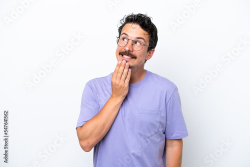Young man with moustache isolated on white background looking up while smiling