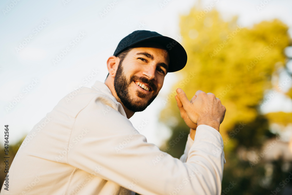 Obraz premium Portrait of a young bearded man wearing a black cap at countryside