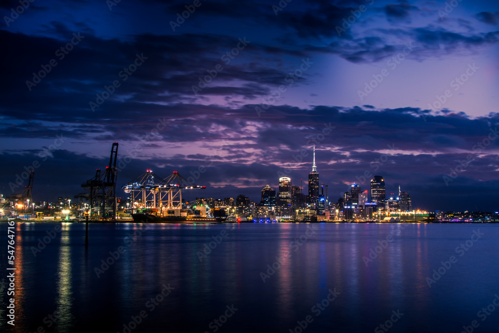 Bright lights of Auckland downtown at night. Dramatic view over Auckland City from North Shore