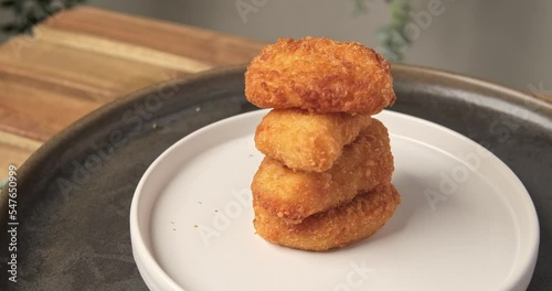 4k video slow motion stock footage,  rotating and close up nuggets chip fries stack on white plate. party snack fast food concept.