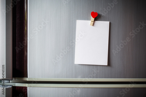Abstract of wooden heart clip with Blank paper and stick paper on refrigerator door. paper note copy space for add text. valentine picture message background