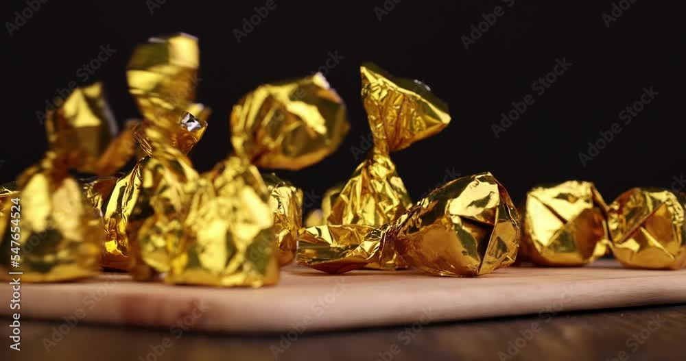 Drop a chocolate candy on the board, throw a sweet chocolate candy with cocoa on the table Drop a chocolate candy on the board, throw a sweet chocolate candy with cocoa on the table