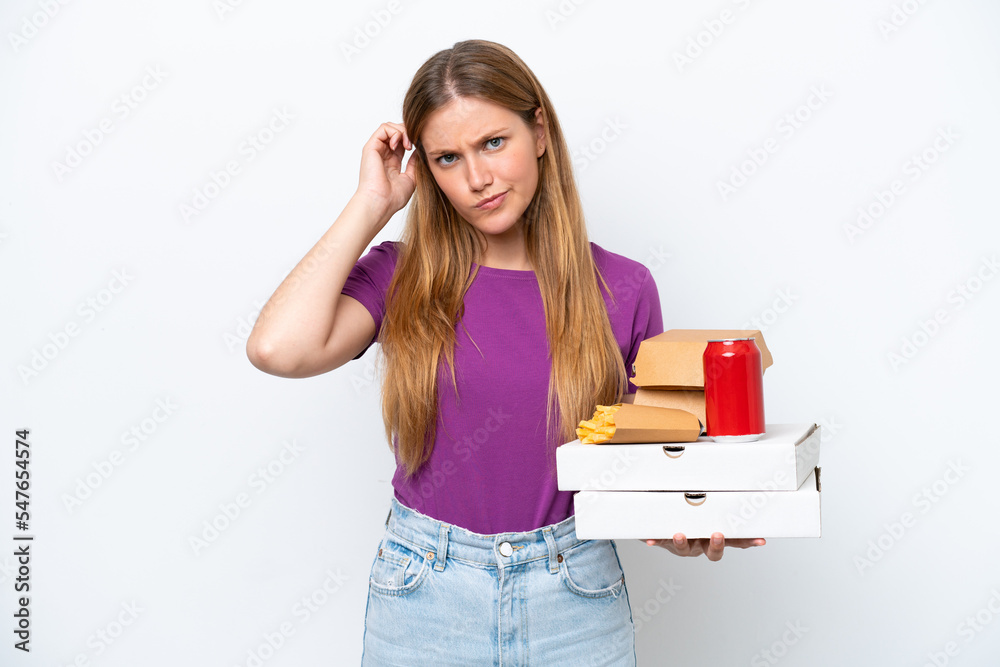 Young pretty blonde woman holding fast food isolated on white background having doubts Young pretty blonde woman holding fast food isolated on white background having doubts