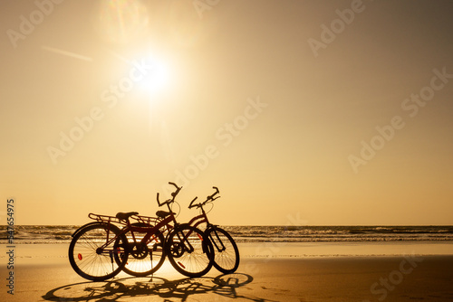 two bicycles and empty beach without people.no body at sunset