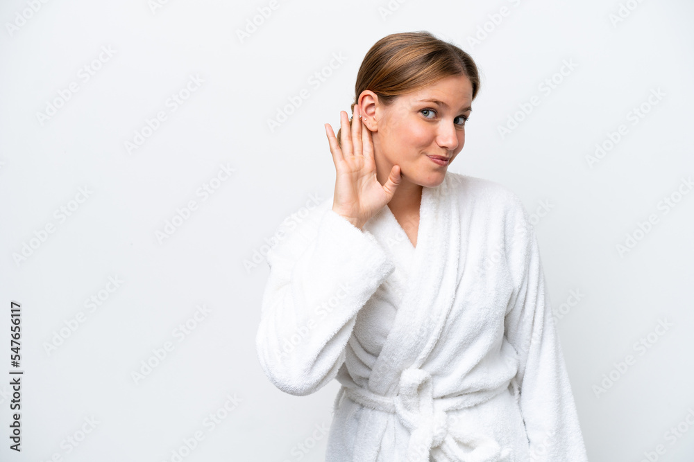 Young pretty blonde woman in bathrobe isolated on white background listening to something by putting hand on the ear Young pretty blonde woman in bathrobe isolated on white background listening to something by putting hand on the ear