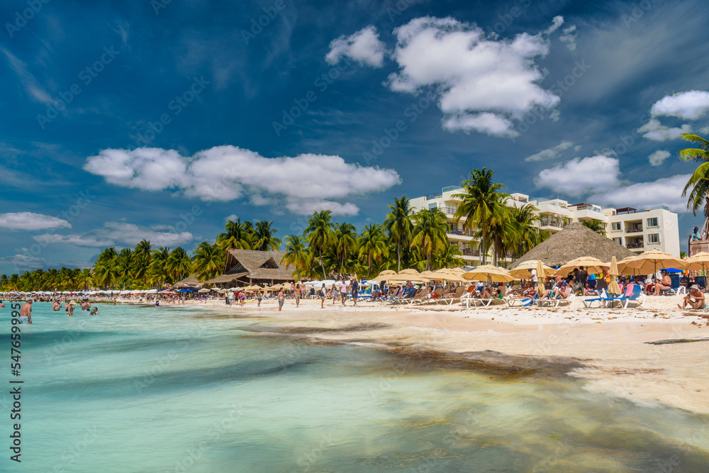 People sunbathing on the white sand beach with umbrellas, bungalow bar and cocos palms, turquoise caribbean sea, Isla Mujeres island, Caribbean Sea, Cancun, Yucatan, Mexico