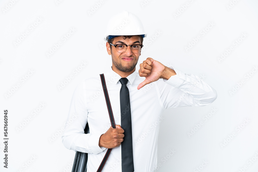 Architect brazilian man with helmet and holding blueprints showing thumb down with negative expression