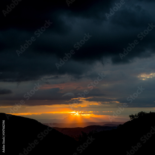 View from Creysseilles near 07000 Privas in the Ardeche France towards the Vercors mountains at sunrise with picturesque sky and rays of sunlight sunbeams photo