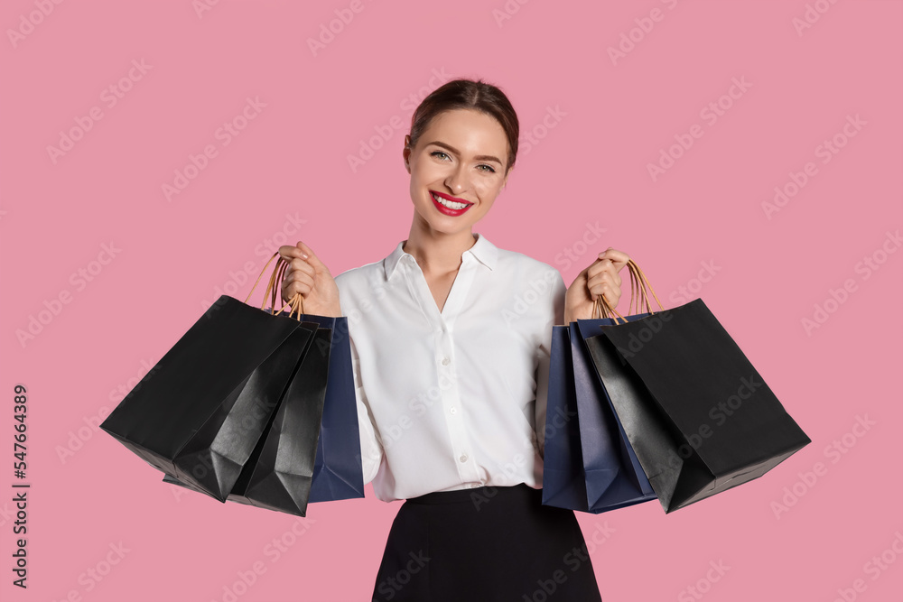 Happy young woman with shopping bags on light pink background. Big sale - obrazy, fototapety, plakaty 