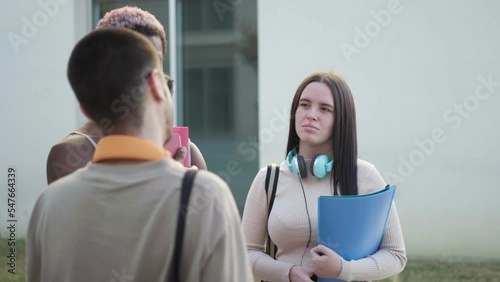 a group of college students are standing on the college campus talking about exams