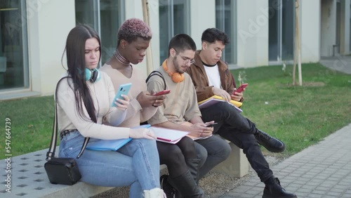 a group of college students looking at their smartphone, addicted to the phone