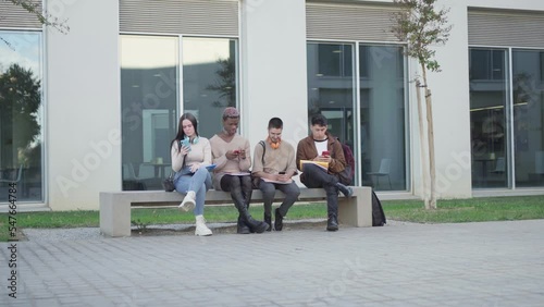 a group of college students looking at their smartphone, addicted to the phone.