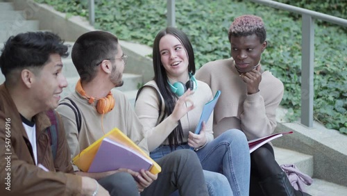 multi-ethnic group of students, take a break sitting on the stairs of the university campus