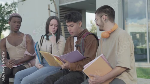 a group of college students talk on the campus of the university during a break