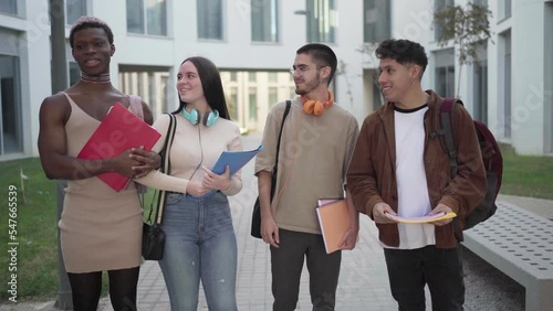 a group of college students are standing on the college campus talking about exams