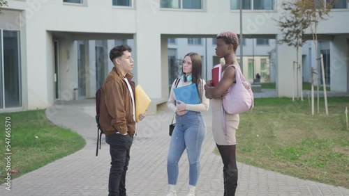 a group of college students at the university campus talking about exams