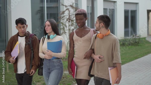 a group of college students walk around the university campus talking about exams