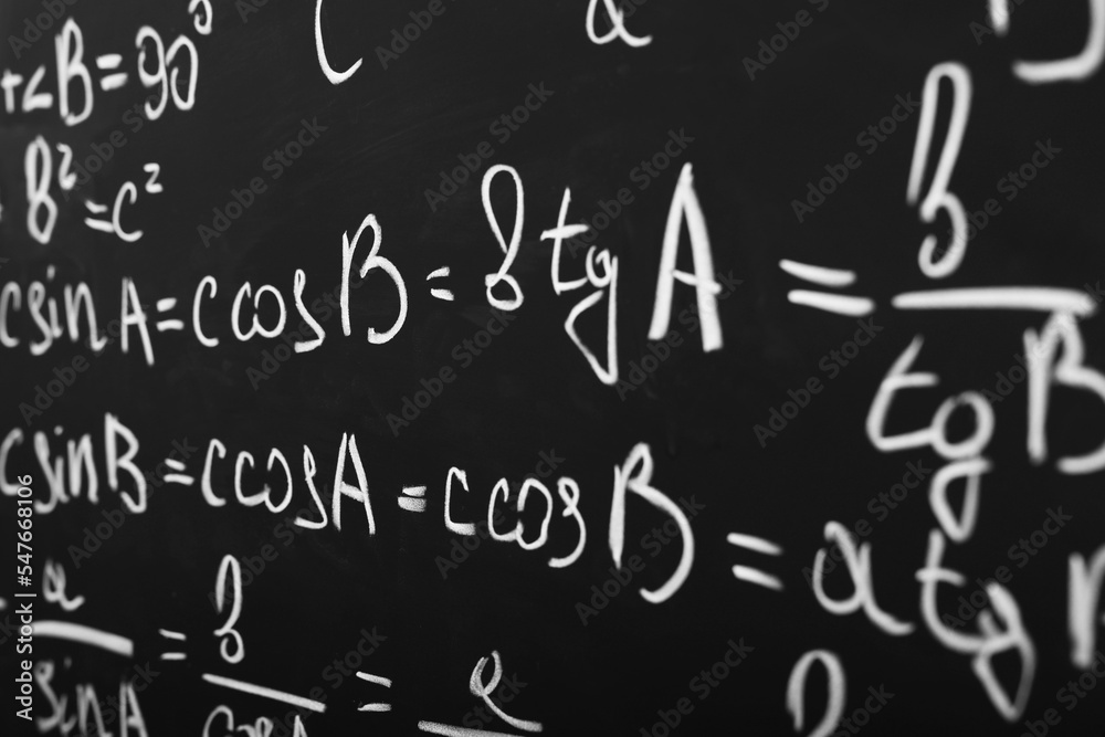 Different mathematical formulas written with chalk on blackboard, closeup Different mathematical formulas written with chalk on blackboard, closeup