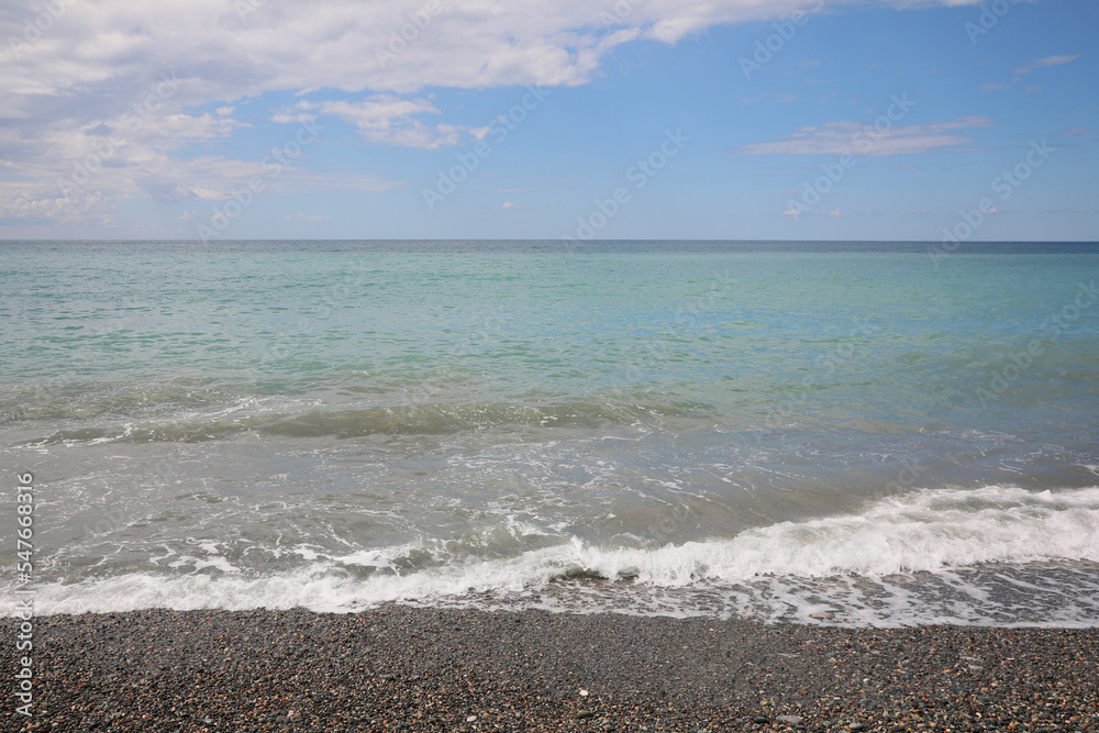 Picturesque view of beautiful sea shore under sky with clouds Picturesque view of beautiful sea shore under sky with clouds