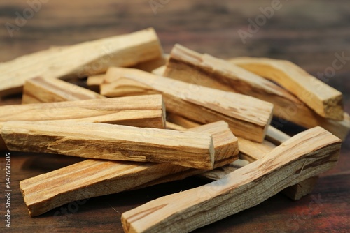 Fototapete Many palo santo sticks on wooden table, closeup