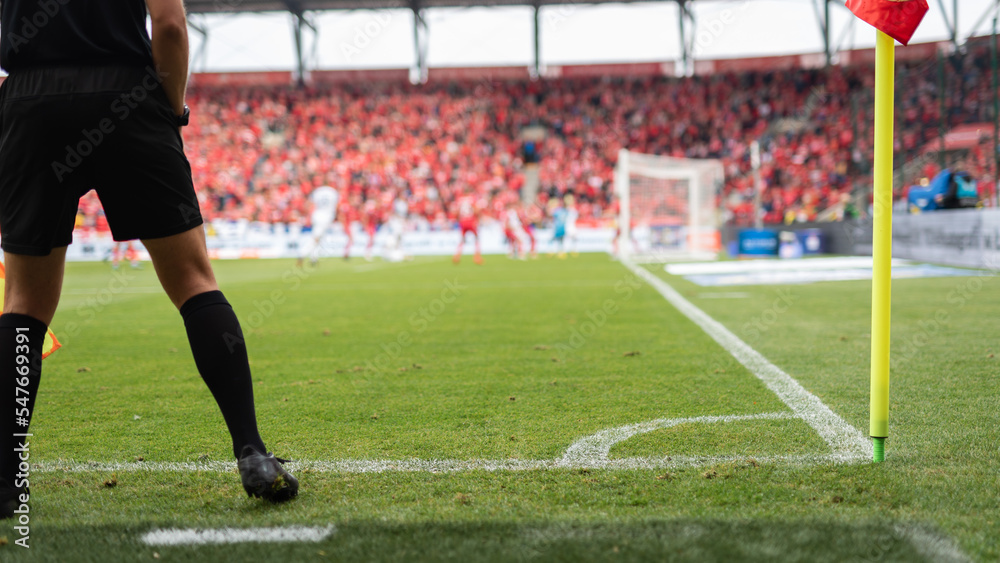 Obraz premium Touchline referee and flag in the corner of soccer pitch