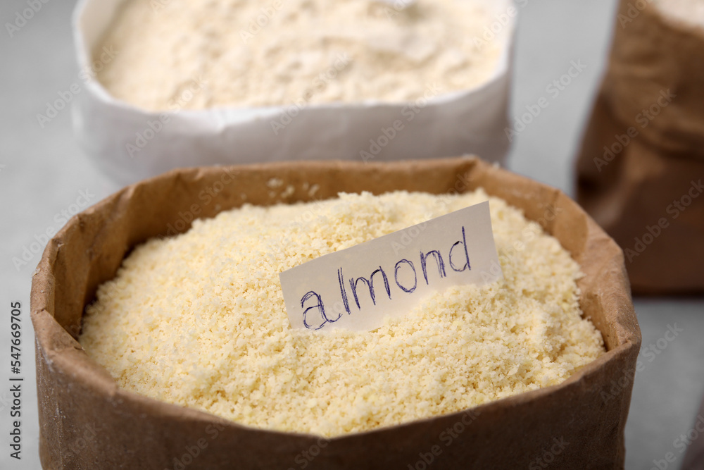 Sack with almond flour on blurred background, closeup Sack with almond flour on blurred background, closeup