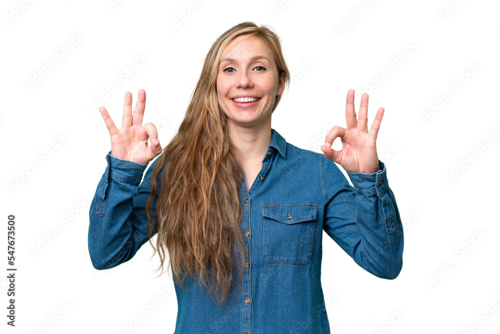 Young blonde woman over isolated background showing ok sign with two hands Young blonde woman over isolated background showing ok sign with two hands