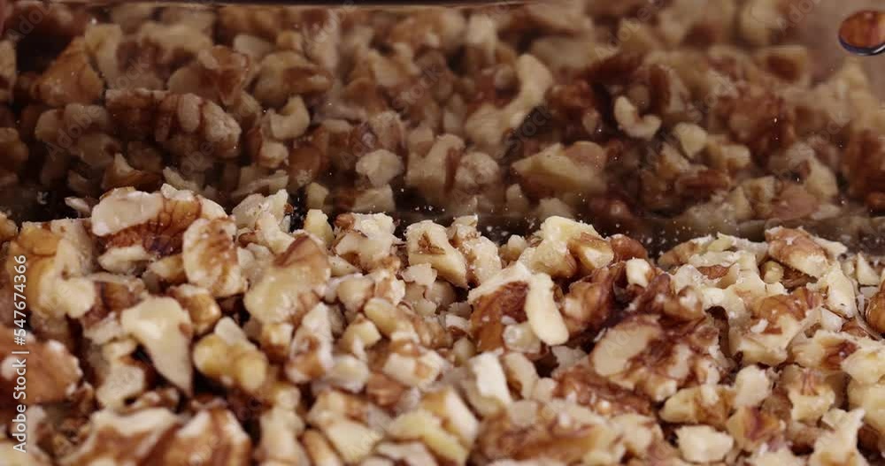 Cut and chop walnuts on a board, cut ripe walnuts into pieces for use in cooking Cut and chop walnuts on a board, cut ripe walnuts into pieces for use in cooking