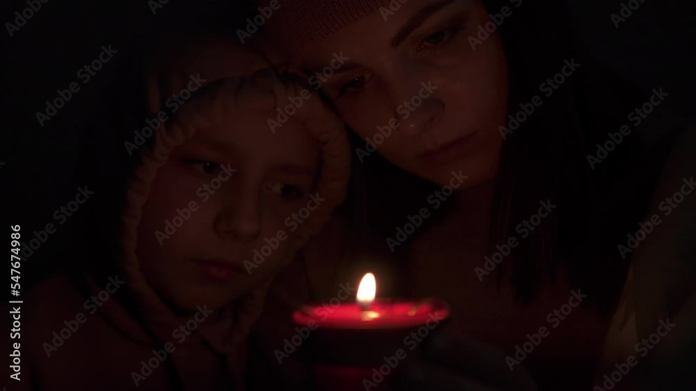 Mom and child are wrapped in a blanket, shivering from the cold on the bed in an unheated apartment and getting hot from a candle. Power outages and central heating due to the energy crisis.
Mom and child are wrapped in a blanket, shivering from the cold on the bed in an unheated apartment and getting hot from a candle. Power outages and central heating due to the energy crisis.