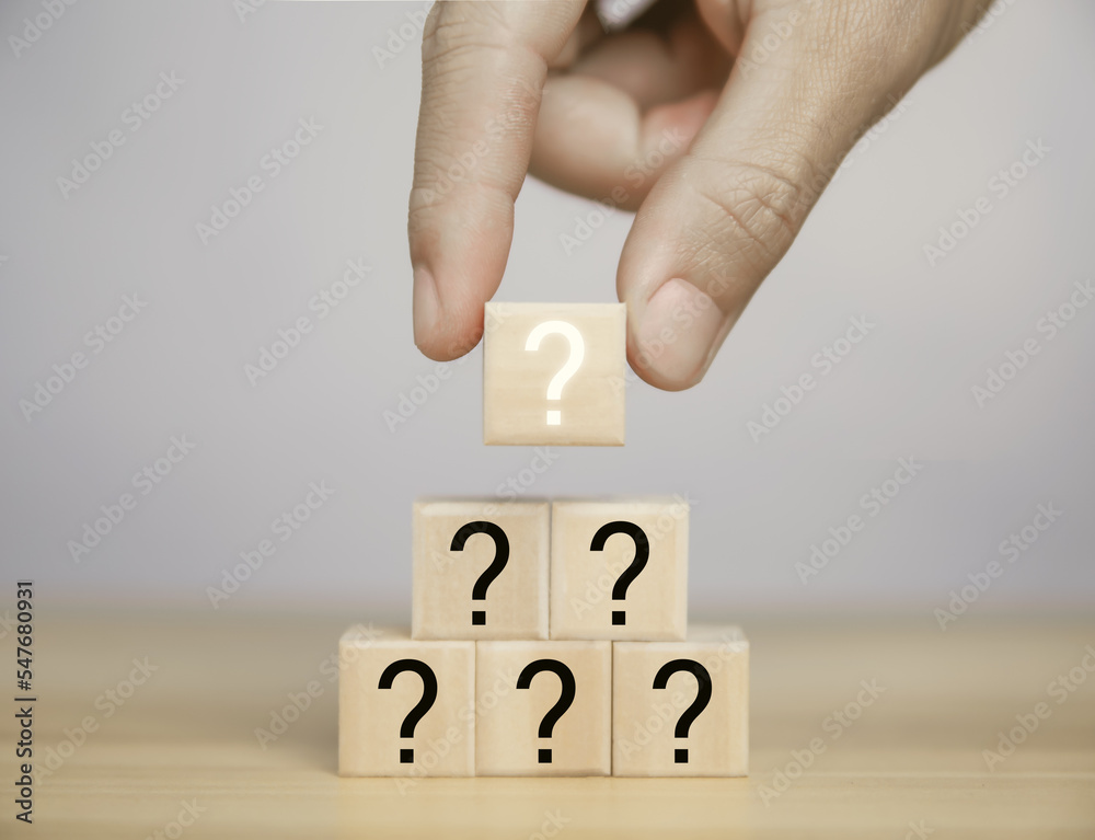 Businessman hand holding wooden block showing question mark icon. choice, idea, confusion, business solution. Businessman hand holding wooden block showing question mark icon. choice, idea, confusion, business solution.